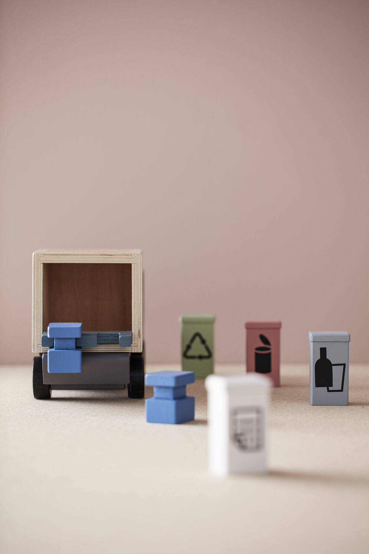 Drewniana śmieciarka z czterema pojemnikami do sortowania odpadów. Pojemniki można umieścić na podnośniku z tyłu i przenieść do ciężarówki. Śmieciarka posiada różne pojemniki z oznaczeniem na: papier, szkło i metal.